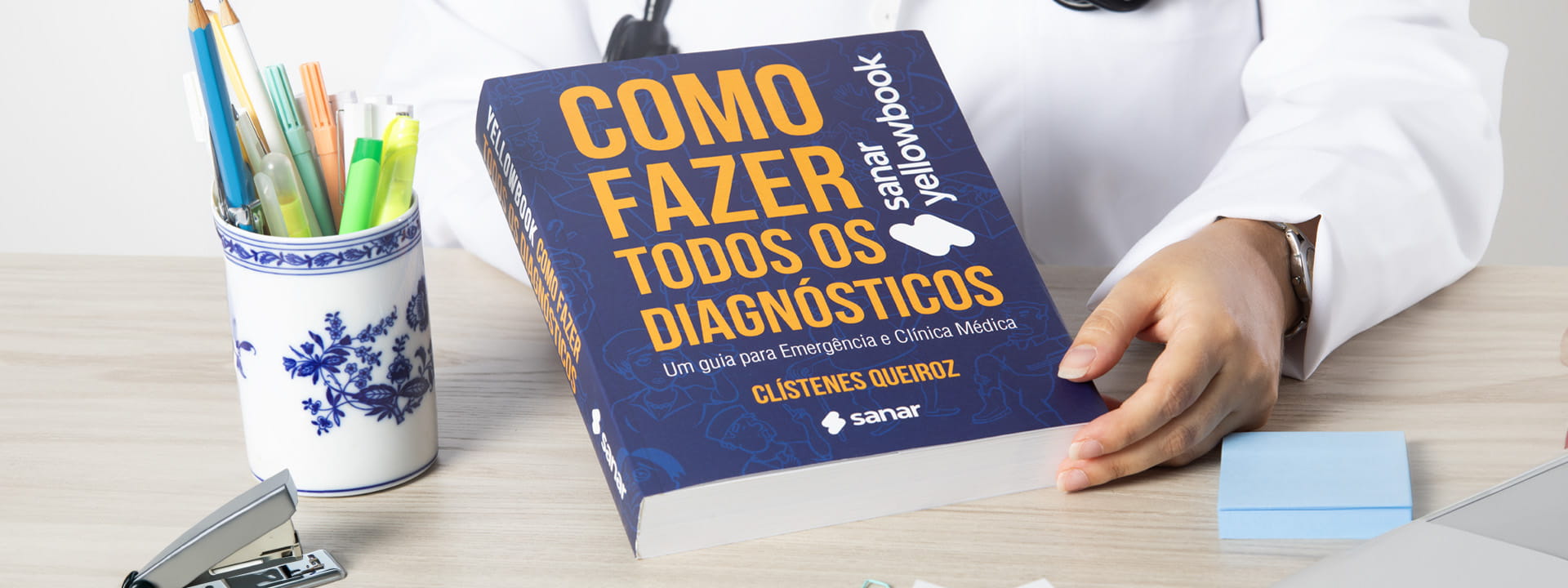 Médica segura o Yellowbook como fazer todos os diagnósticos em mesa de estudo